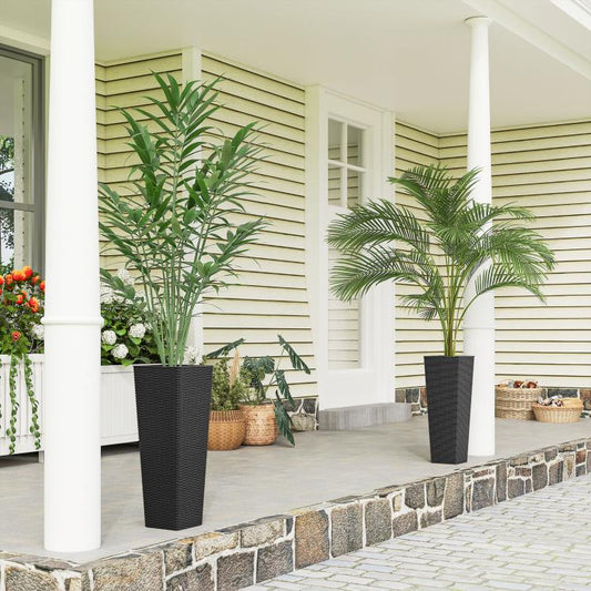 Two black tall woven planters with potted plants on an outdoor patio