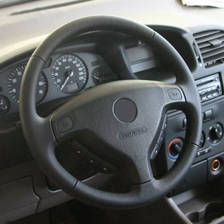 Steering wheel horn pad with airbag emblem and side control buttons in the car cabin