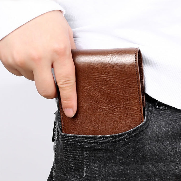 Brown leather wallet sliding into a jeans pocket