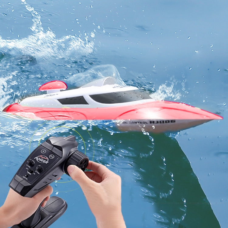 Red and white RC racing yacht with remote controller, close front view on water