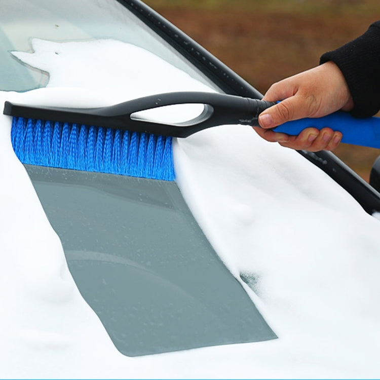 2-in-1 snow shovel with blue bristle brush pressed to snow on a windshield