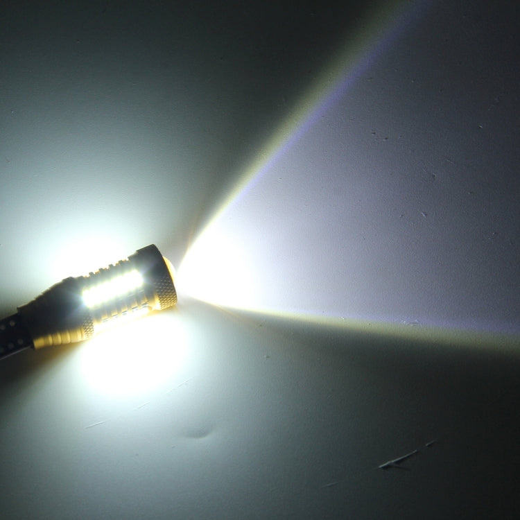 Lit gold LED car clearance bulb shining a bright white beam across a surface