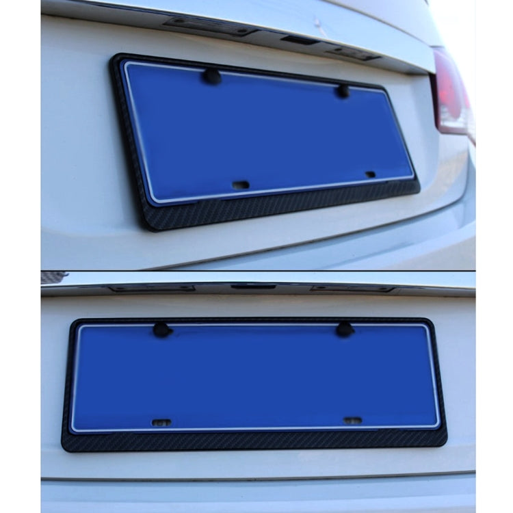 Black carbon fiber license plate frame mounted on a vehicle rear plate