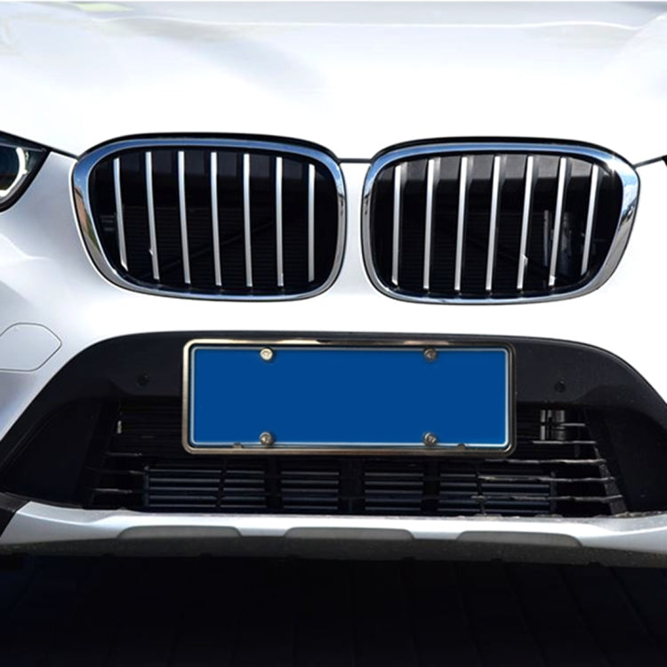 Silver license plate bracket frame mounted on car front, blue plate insert