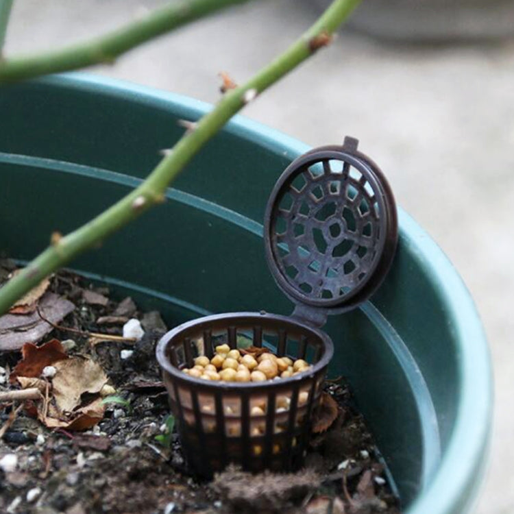 Bonsai fertilizer box in planter soil with open basket and small pellets