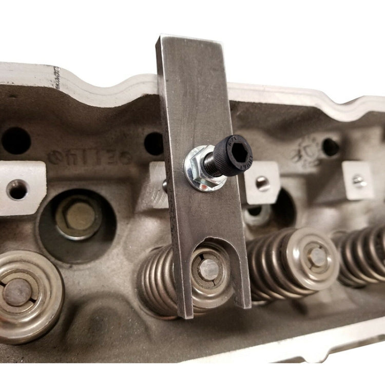 Valve spring compressor tool clamped on engine cylinder head near valve springs