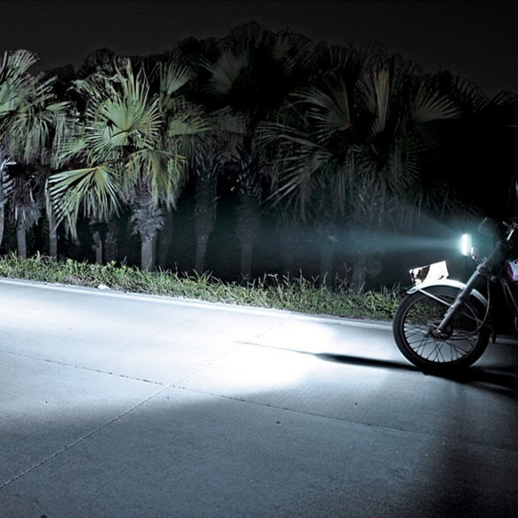Motorcycle with LED headlight on, bright white beam illuminating the road