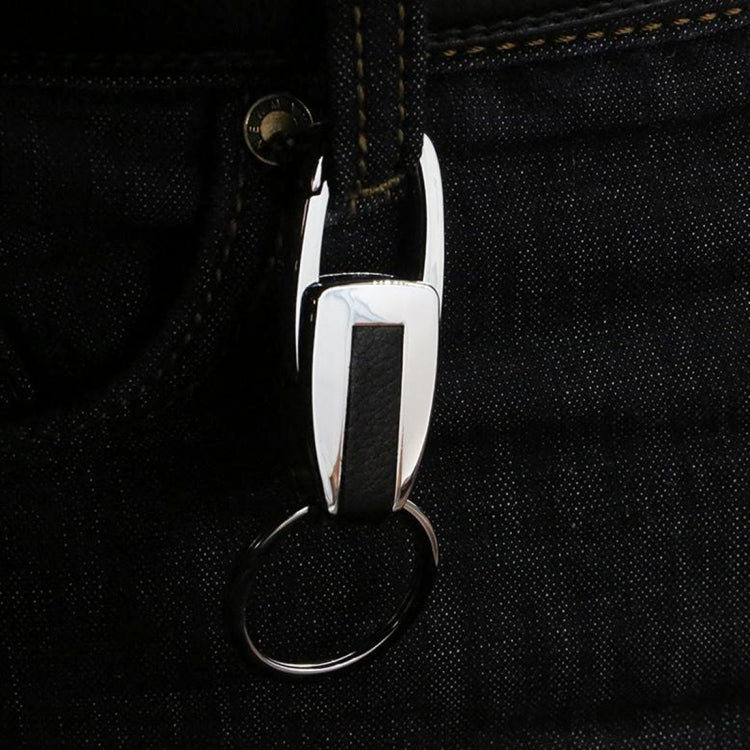 Metal key chain with ring and clip, hanging from black fabric