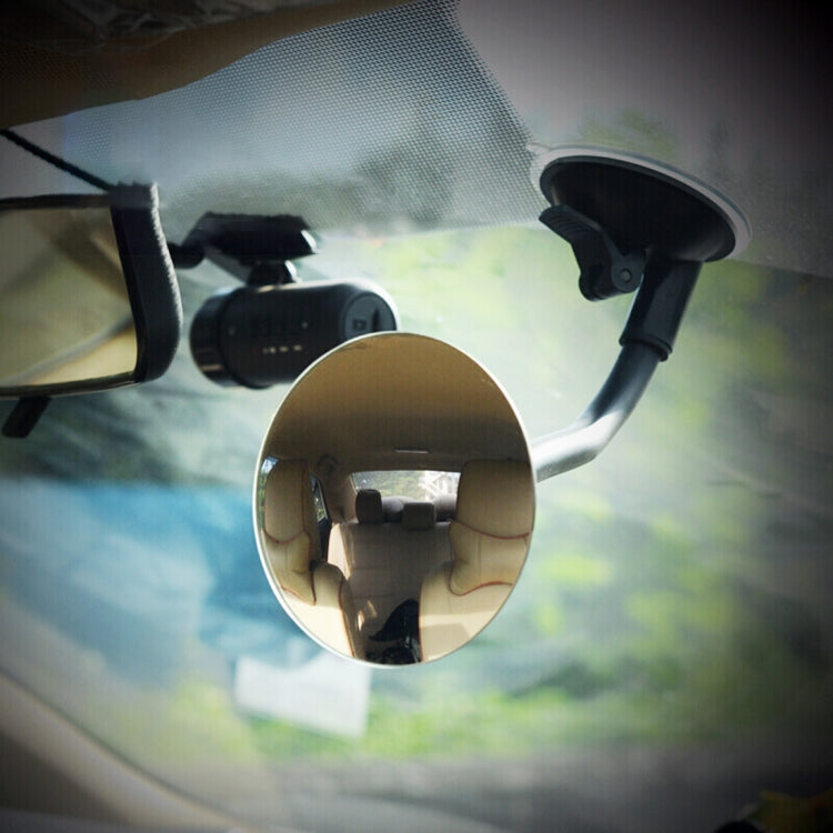 Round convex blind spot mirror attached to car window with suction mount