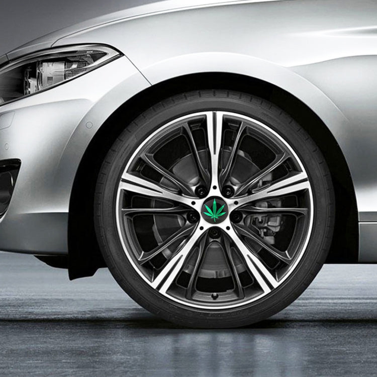 Car wheel hub sticker on rim center: green leaf emblem on black hub cover