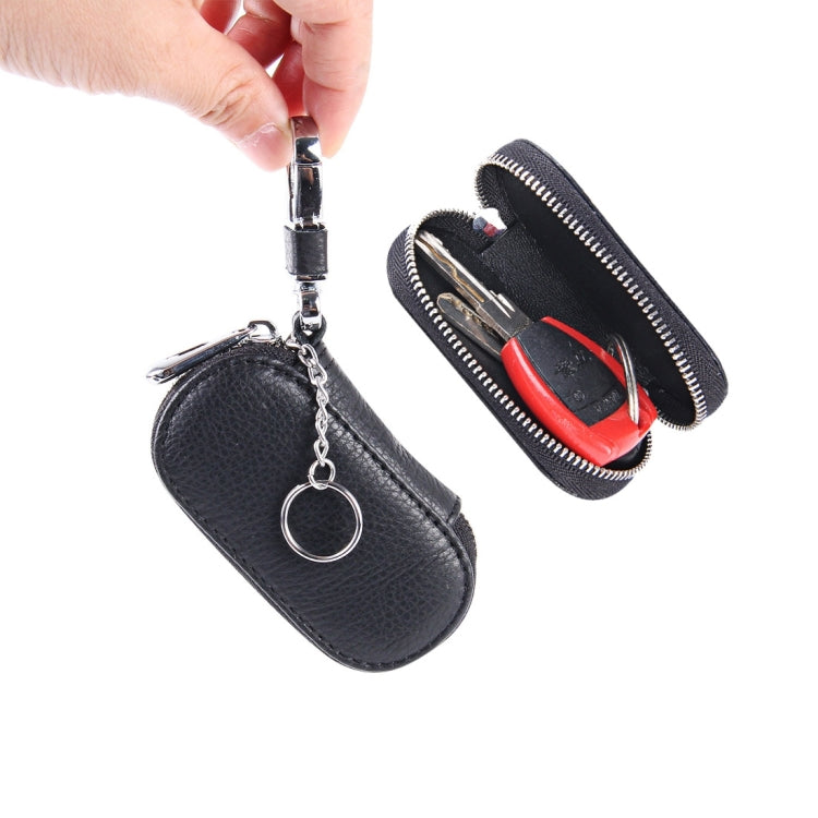Two black leather zipper key holder wallets with key rings, one held by hand
