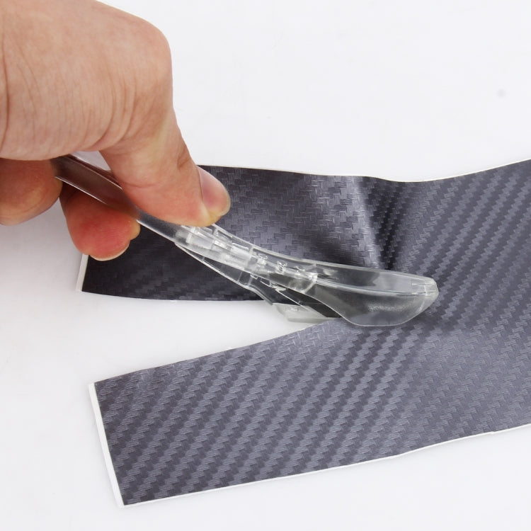 Transparent cutter tool trimming dark vinyl film with curved blade