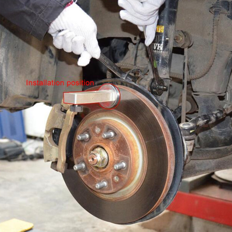 Wheel alignment gauge tool placed on brake rotor during wheel alignment