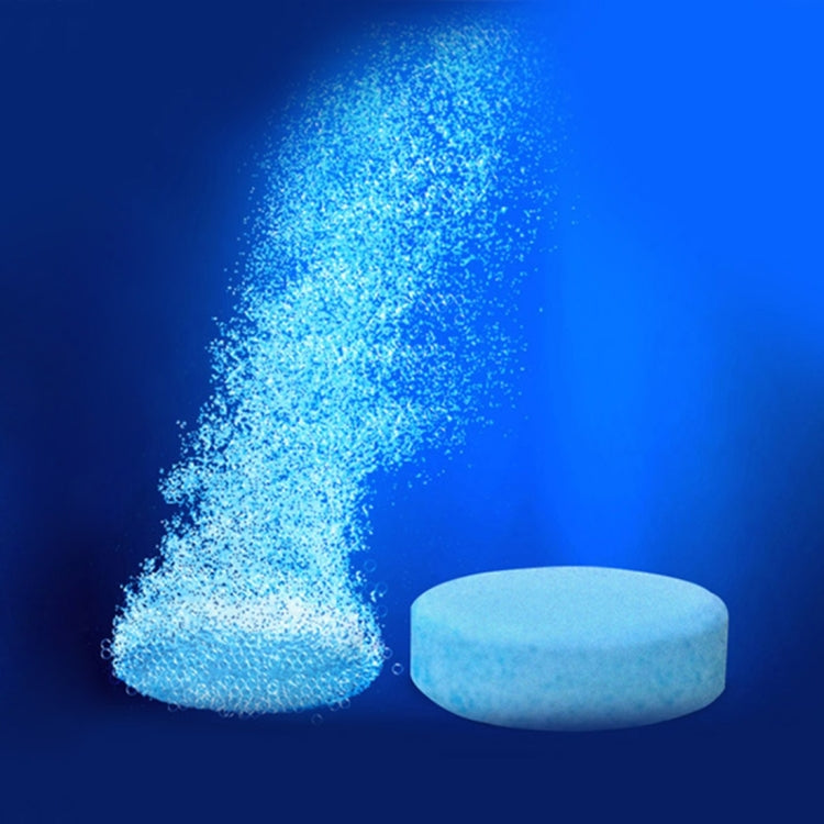 Round blue-white glass cleaner tablet beside foamy blue granules