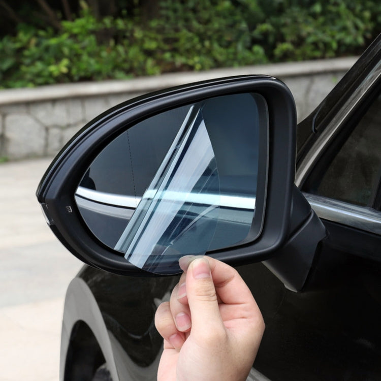 Clear anti-fog protective film being applied to car side rearview mirror window