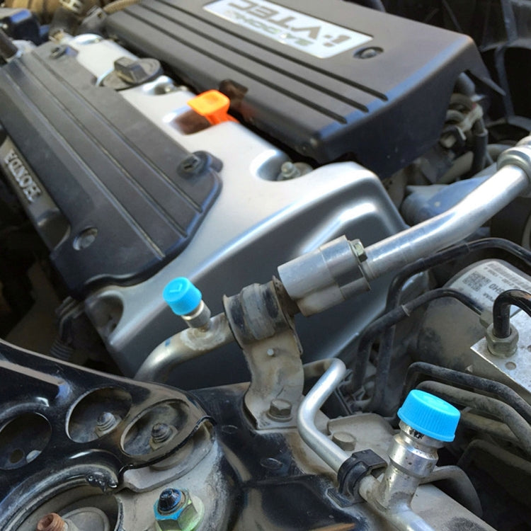 AC high-pressure valve caps on car components, light blue tops