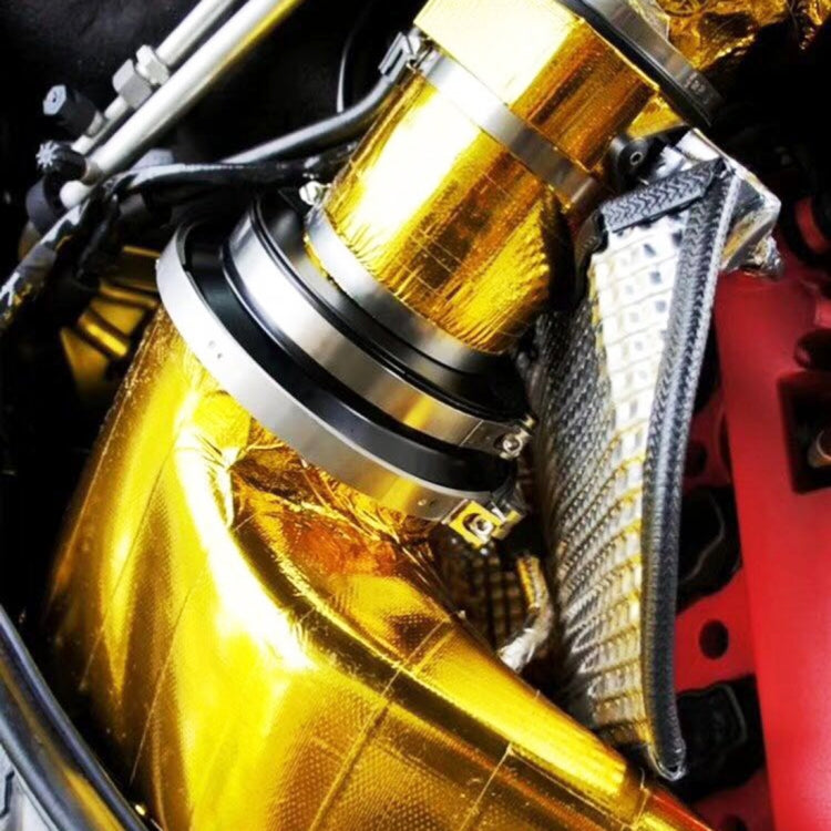 Gold exhaust heat shield wrap beside silver heat shield sleeve on the exhaust