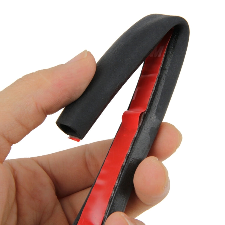 Flexible black D-shaped car sealing strip with red inner channel; held in hand