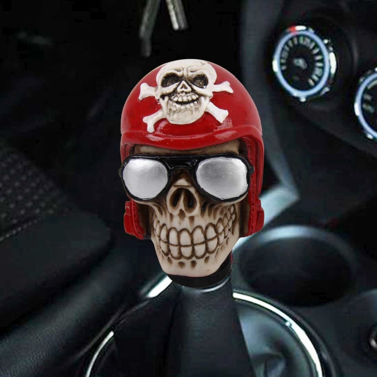 Skull-shaped gear shift knob cover, red helmet with silver goggles on black shaft