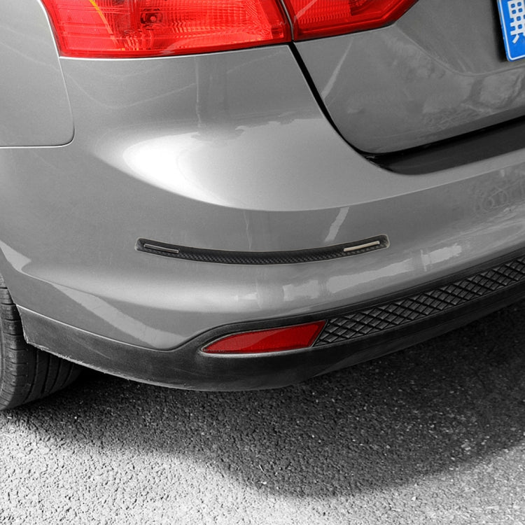 Anti-collision trim strip on white rear bumper, black with silver center