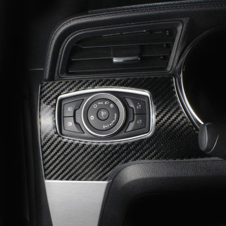 Installed headlight switch panel trim with red-and-black carbon fiber pattern around control