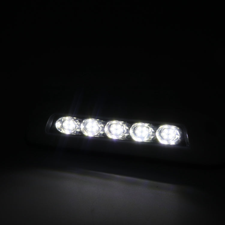 Lit LED deck dome stair light bar with five bright circular LEDs in dark setting.