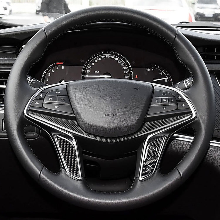 Close-up of steering wheel center trim: carbon fiber inserts on side spokes