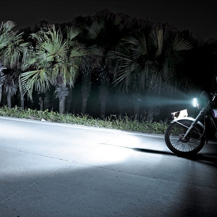 BA20D motorcycle headlight bulb shines on road, white projector beam for motorcycles.