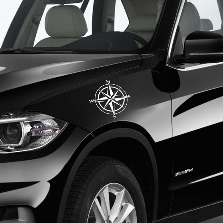 White compass rose decal on car door panel, with N W E S letters