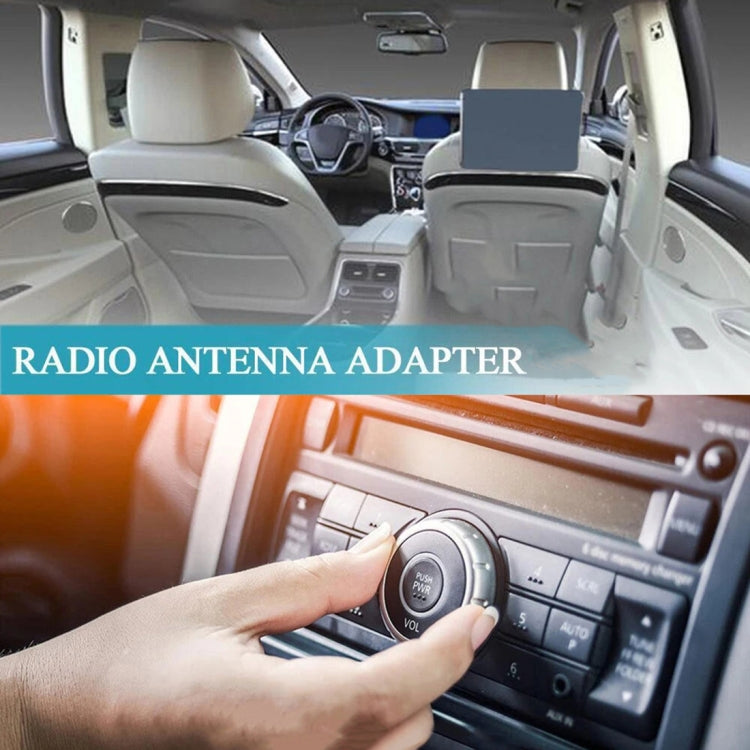 Car radio antenna adapter cable near stereo controls, hand adjusting radio buttons
