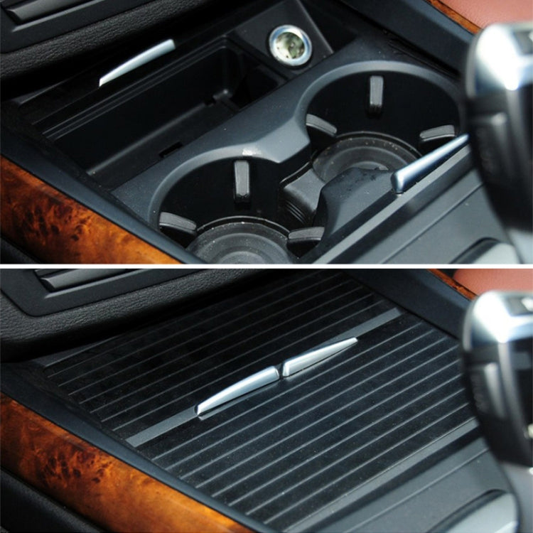 Installed rear cup holder insert with ribbed mat and metal pull tabs
