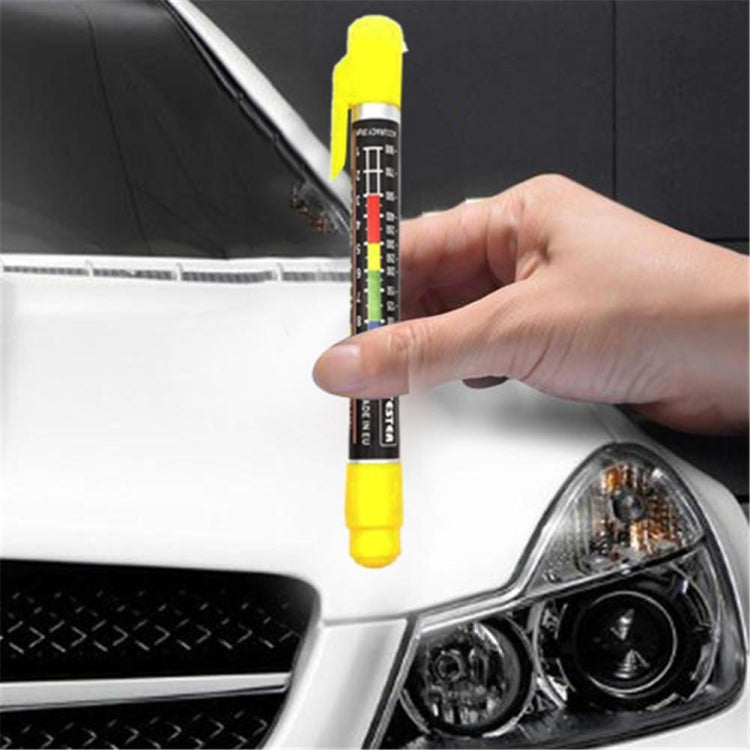 Paint thickness gauge measuring on car front near headlight, yellow tip