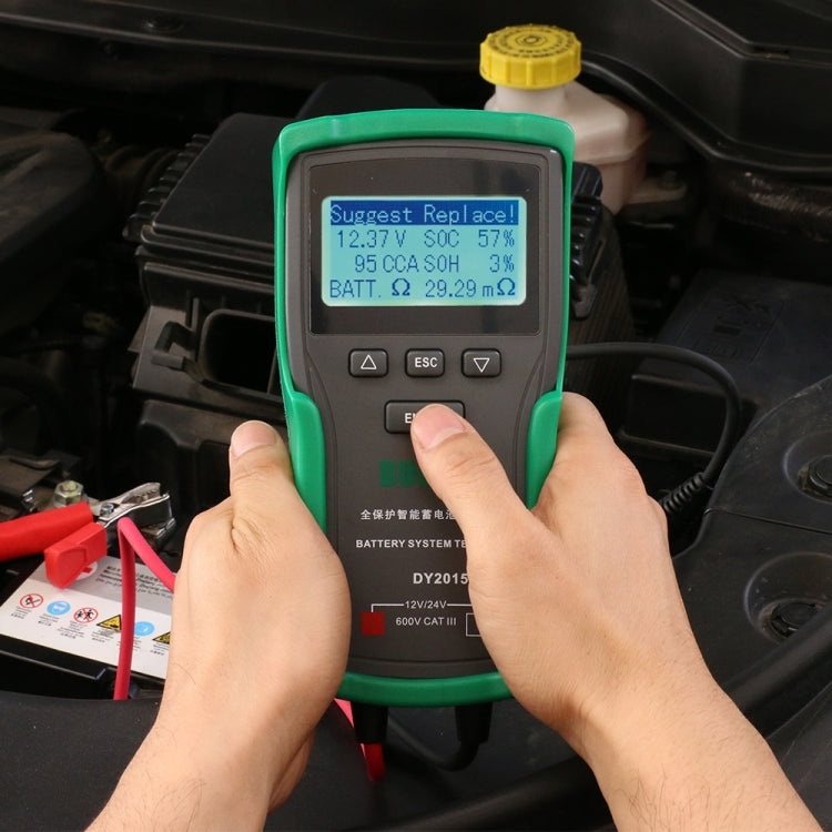 Green battery system tester with LCD screen and operator hands pressing buttons