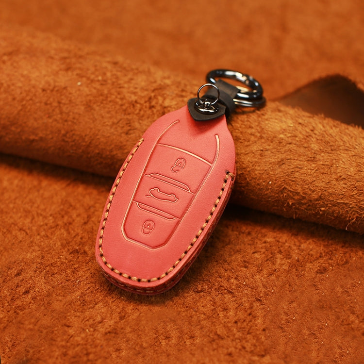 Red cowhide leather key protective cover with embossed control icons and stitched edges.