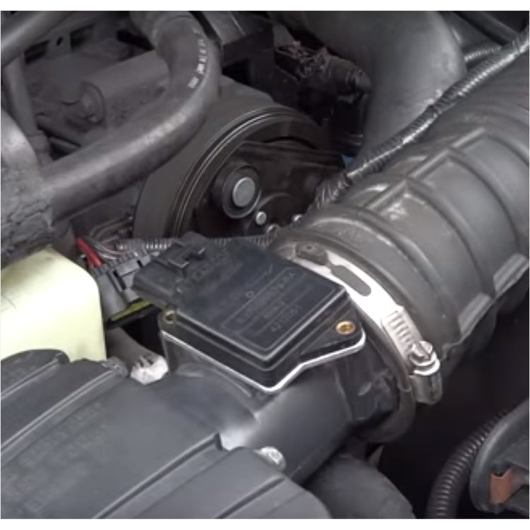 Mass air flow sensor installed in engine bay near intake duct and wiring harness