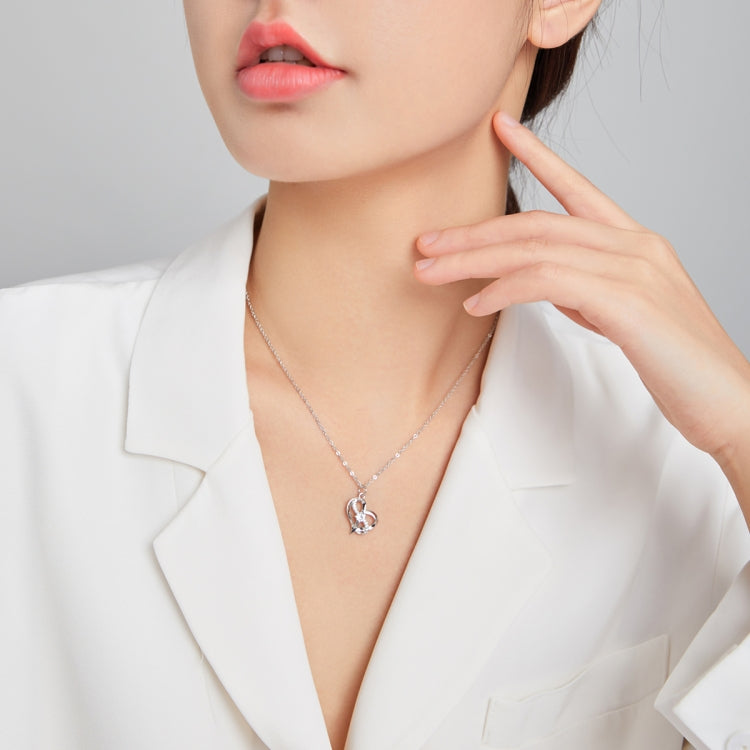 Sterling silver heart pendant necklace worn close to the neck with crystal accents