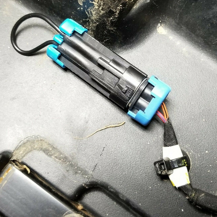 ATV seat belt harness bypass plug installed on wiring with connector and black/blue housing