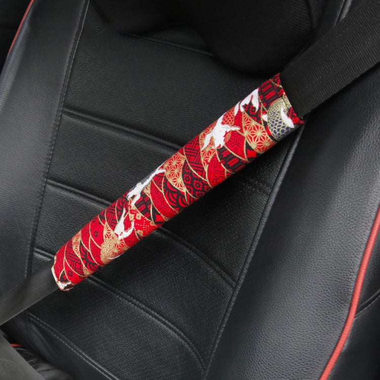Car seat belt protective cover with red and white festive pattern.