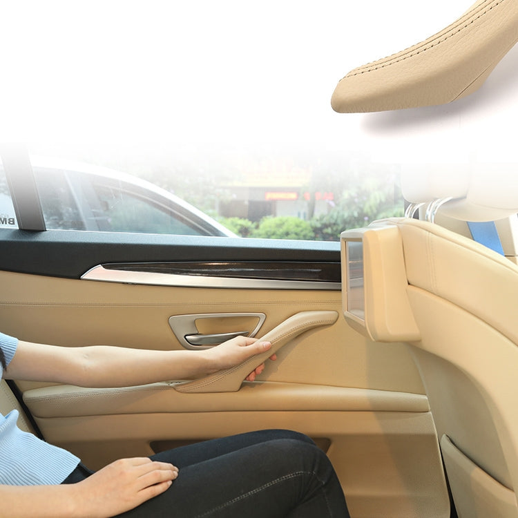 Beige left side car door inner handle assembly on interior door panel with armrest switch