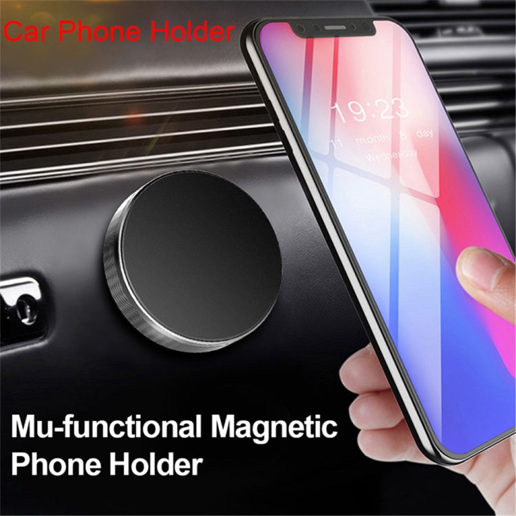 Magnetic car phone holder disc holding a smartphone on the dashboard