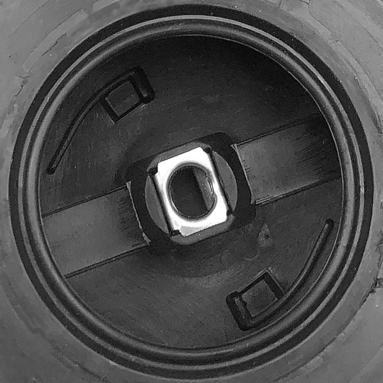Close-up of chainsaw air filter interior: black circular cavity with metal center nut