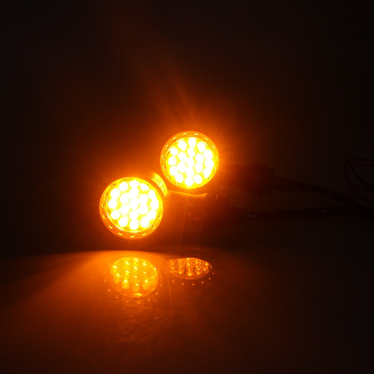 Glowing amber motorcycle LED turn signals with reflective lens faces