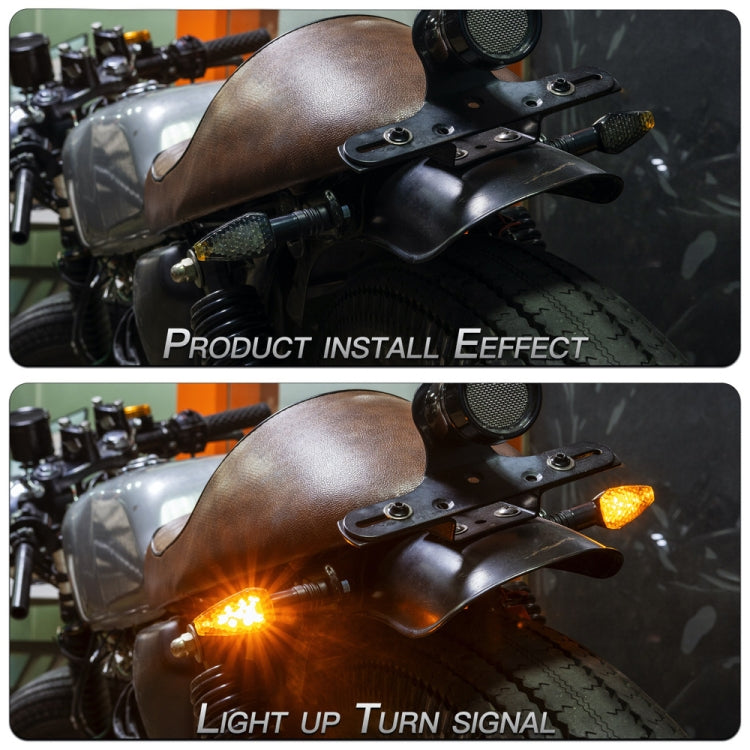 Motorcycle LED turn signal installed and lit, black housing with amber-yellow lens