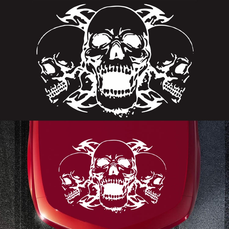 Red three-skull graphic decorative car sticker on a dark surface