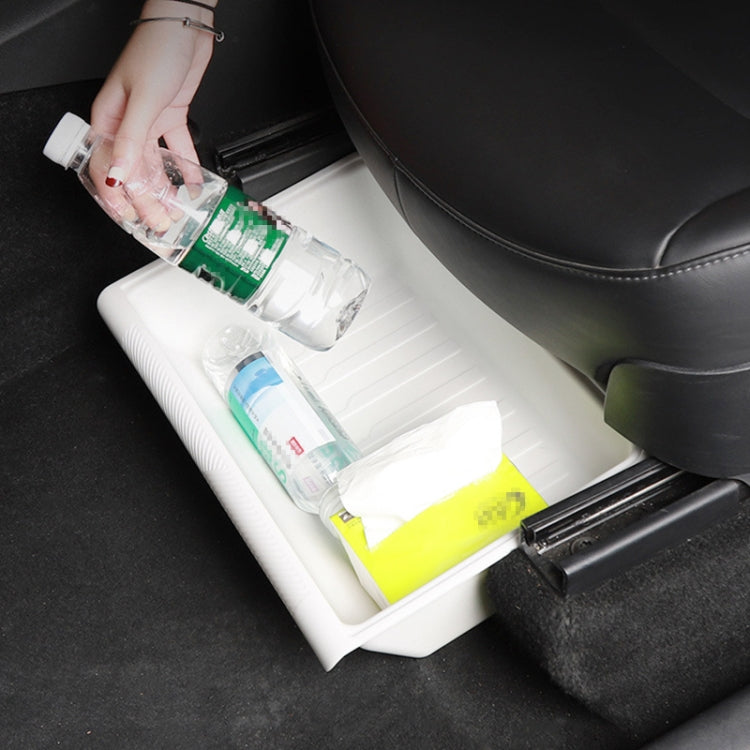 White TPE under-seat storage tray holding bottles and small items
