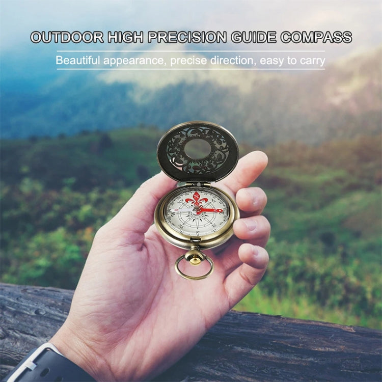 Flip pocket watch compass held in hand with open lid and engraved dial
