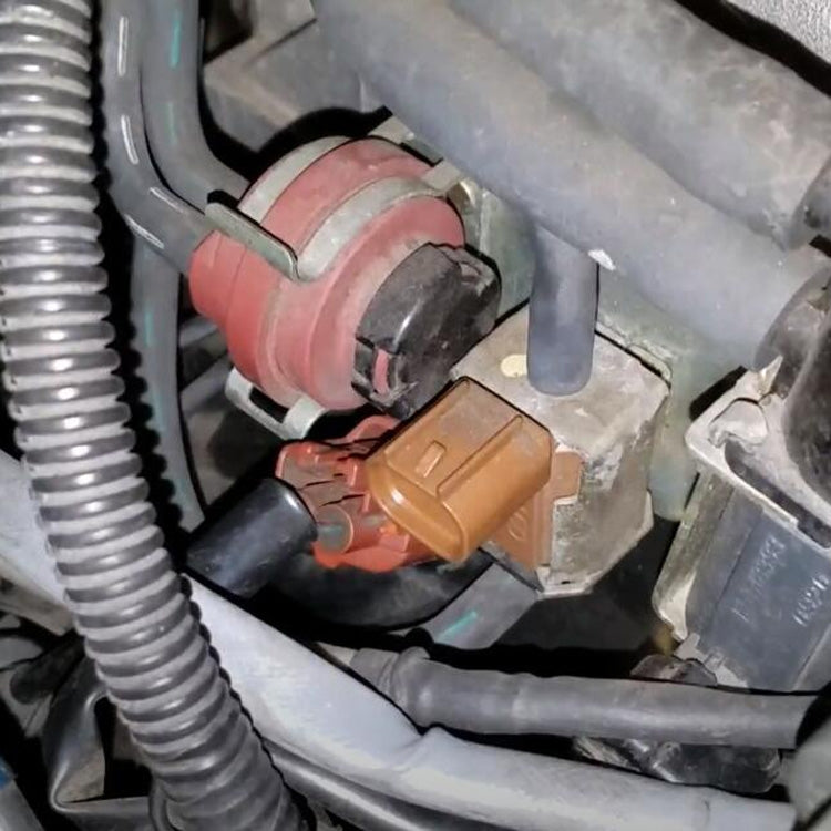 Auto vacuum solenoid valve in engine bay, brown connector and black hose