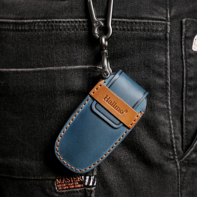 Blue leather key fob cover with tan accents and metal keyring attached to jeans