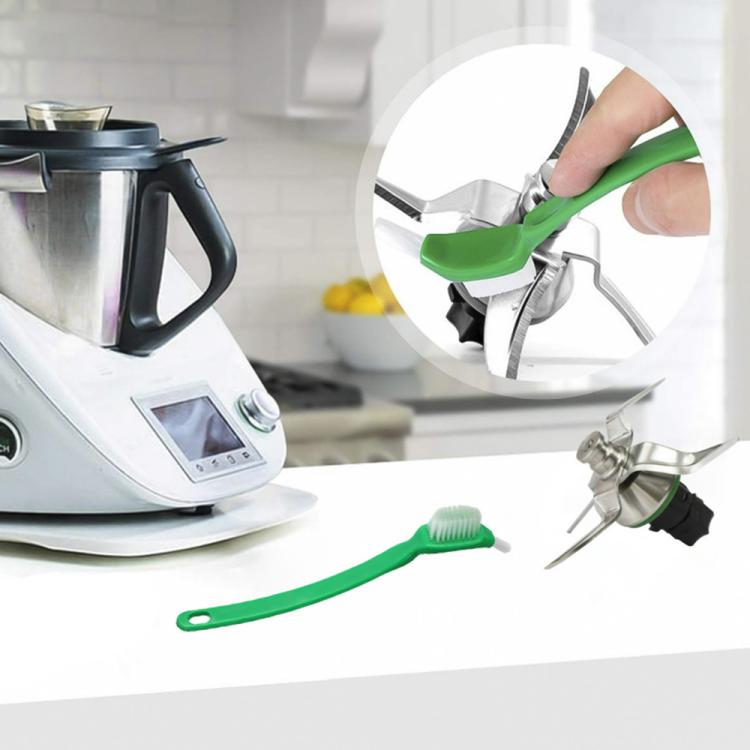 Green cleaning brush with white bristles being used on appliance parts