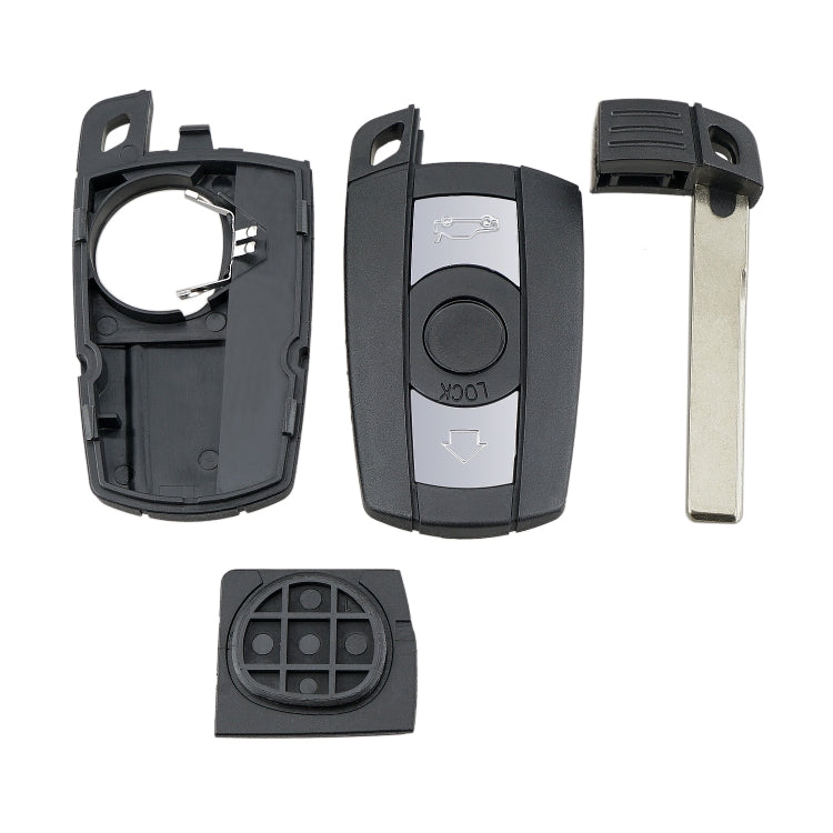 Disassembled car key fob parts: shells, metal blade, and button insert